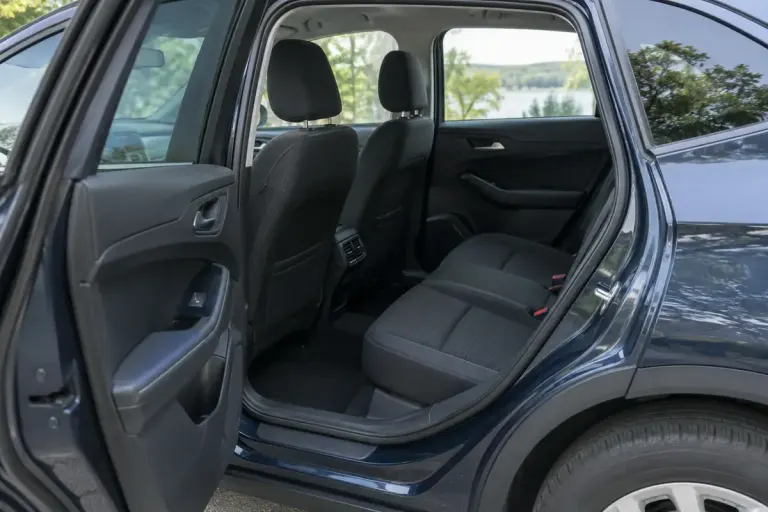 An empty parked family car with rear passenger door open and rear seat visible.